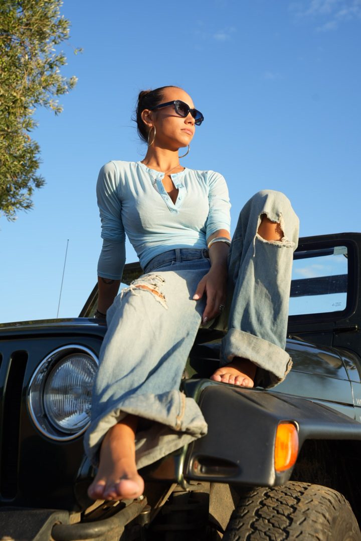 Ejemplo de post: modelo con gafas de sol sentada sobre un todoterreno